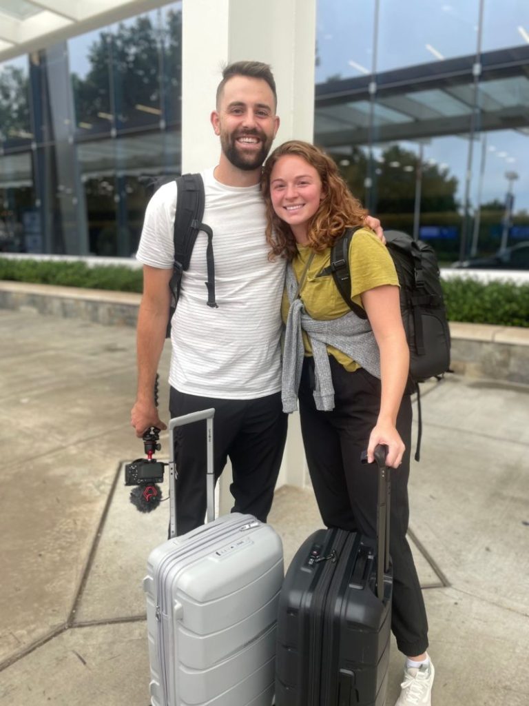 couple at airport leaving for 6 months of travel itinerary around the world