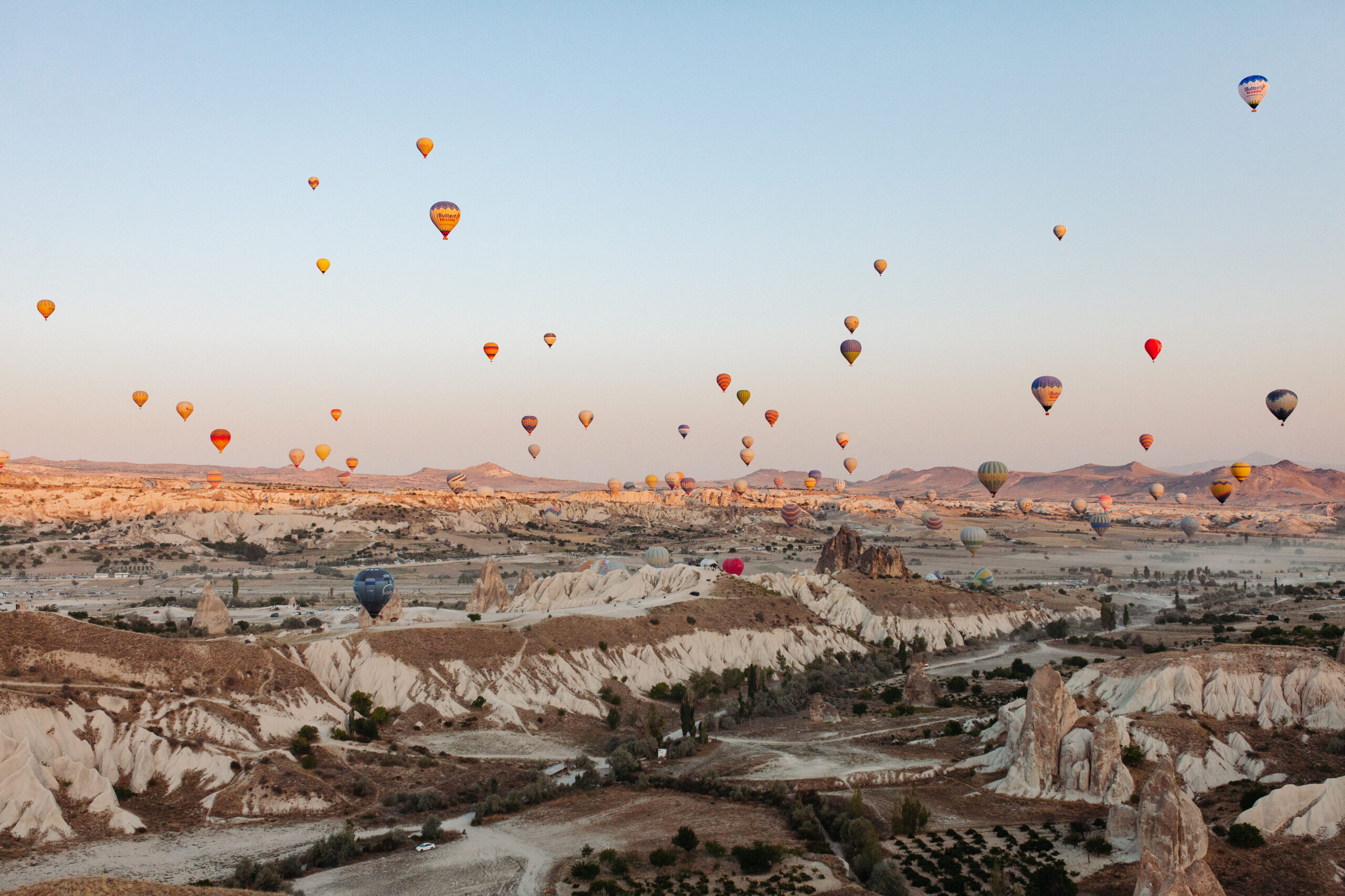 colorful hot air balloons flying over desert in Cappadocia Turkey