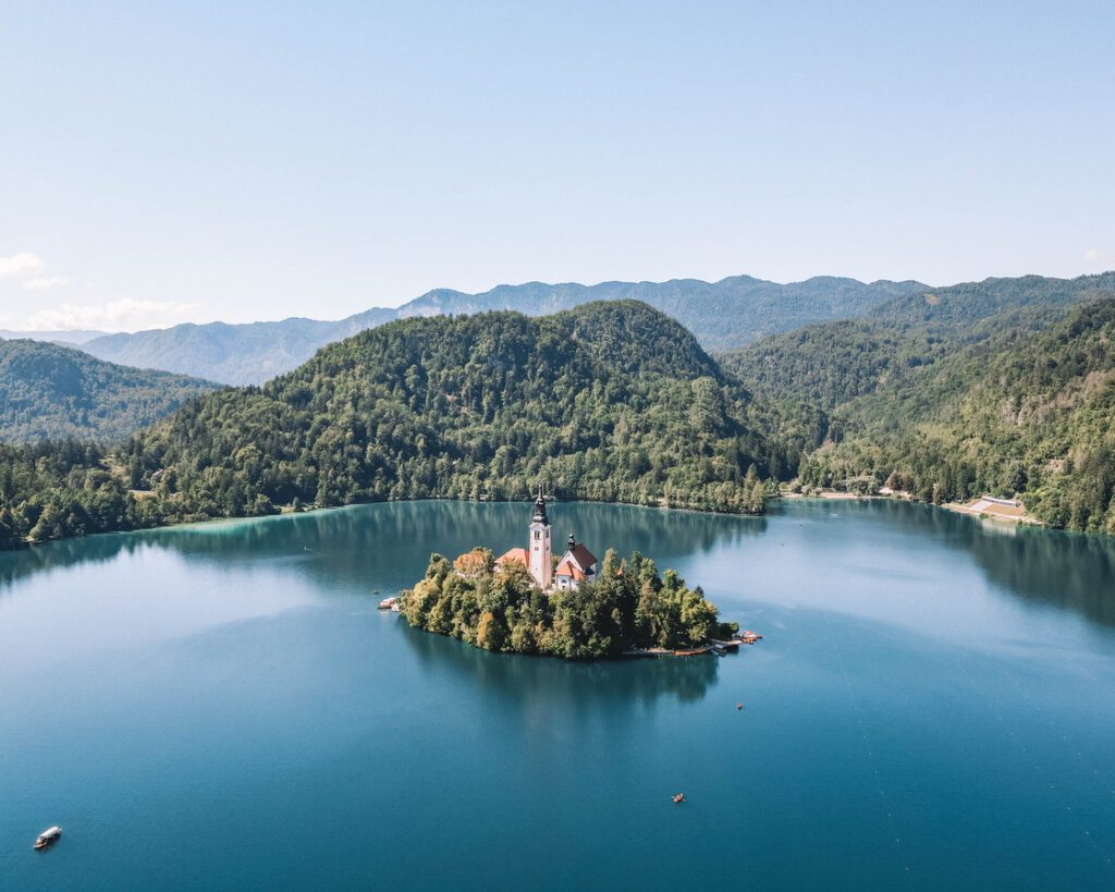 island in middle of blue lake with church