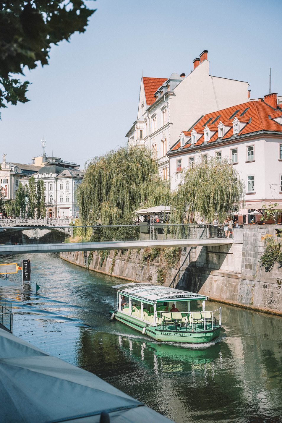 green boat going down river in ljubljana