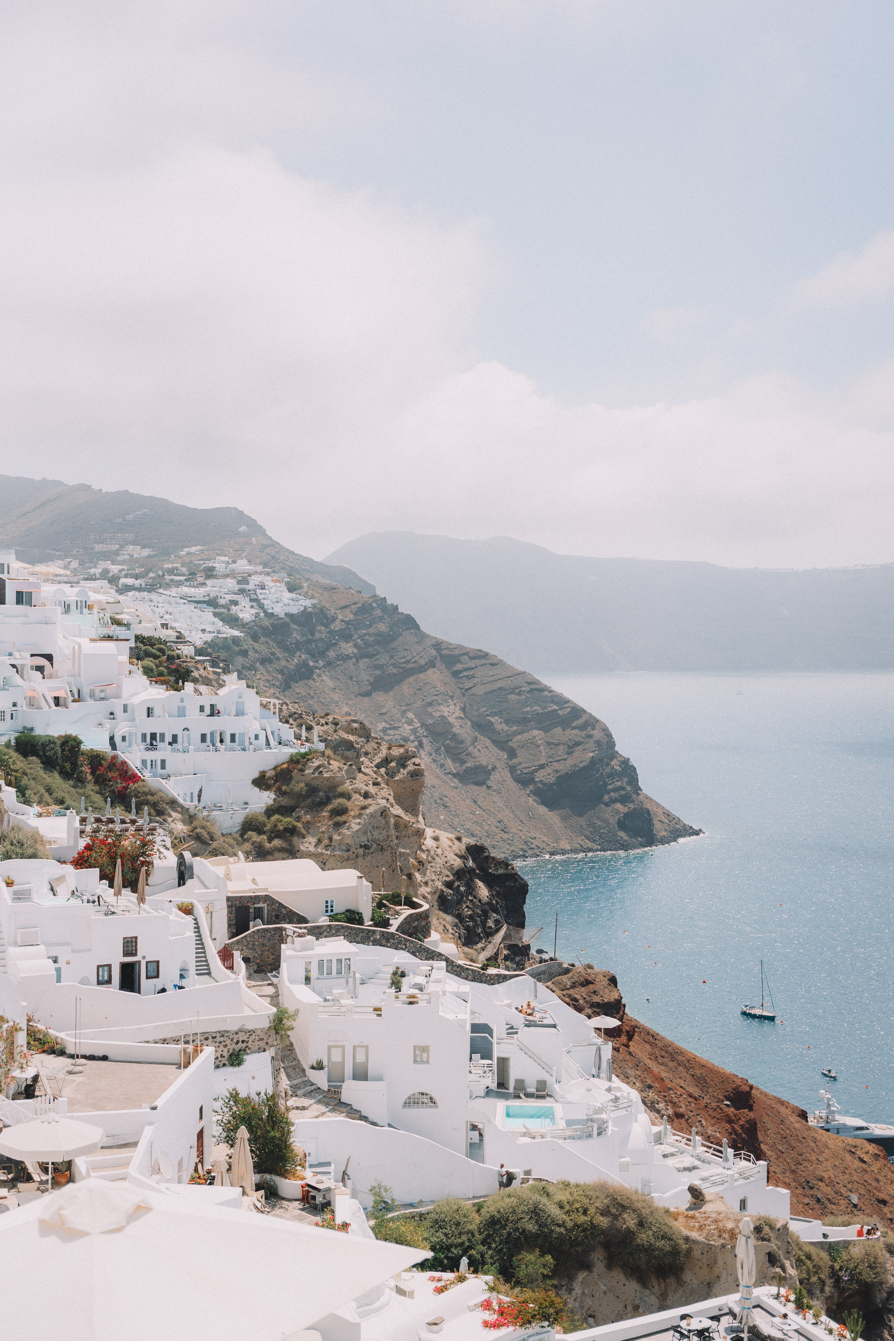 white washed greek buildings on cliffside overlooking sea in Oia Greece 2 week itinerary