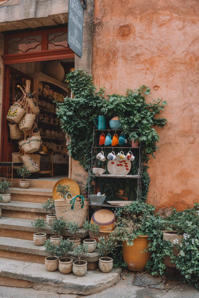 wicker bags and handmade ceramic mugs displayed outside shop in Roussillon, France