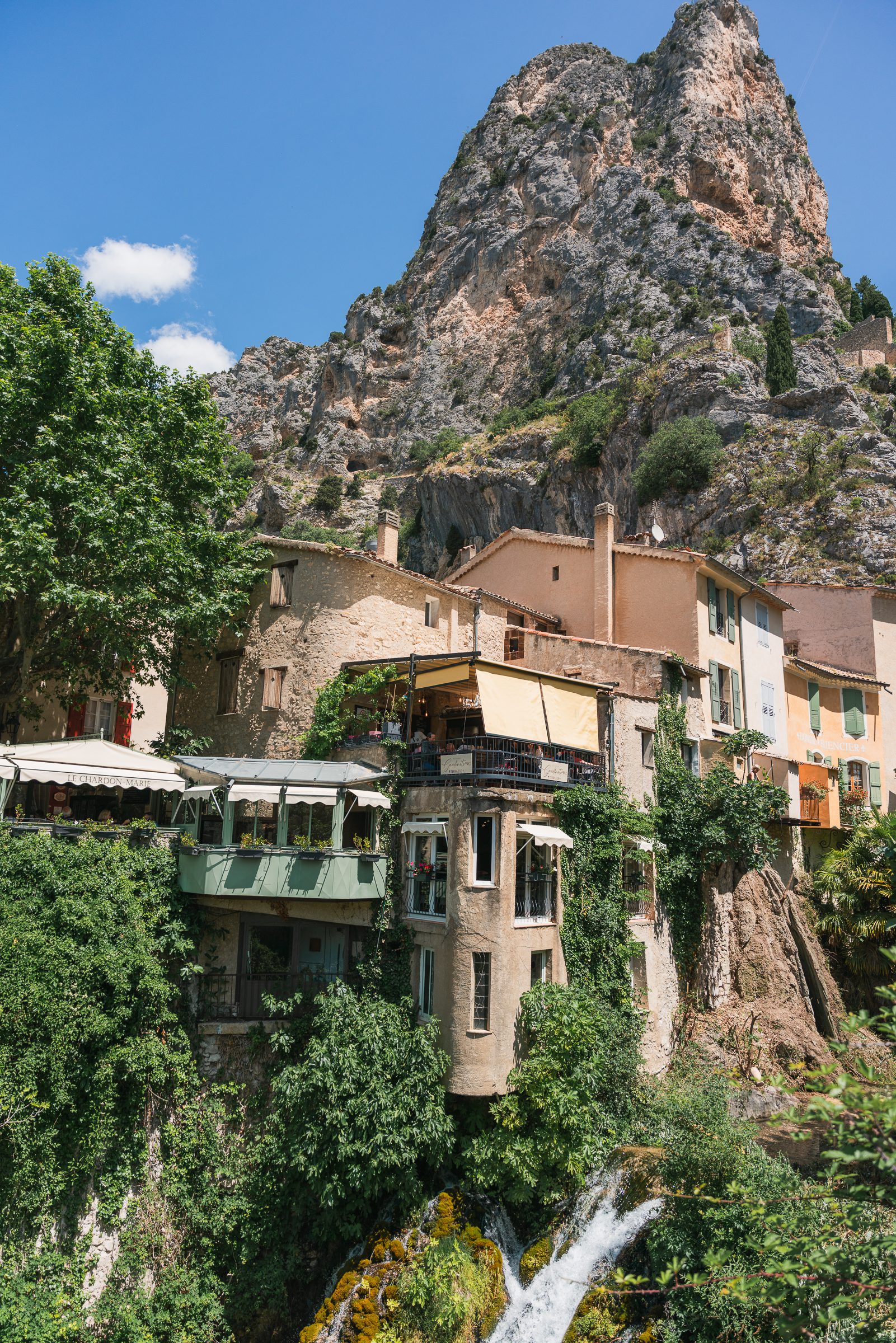 building and terrace built over waterfall in Moustiers-Sainte-Marie, France places to go on a 10 day South of France itinerary