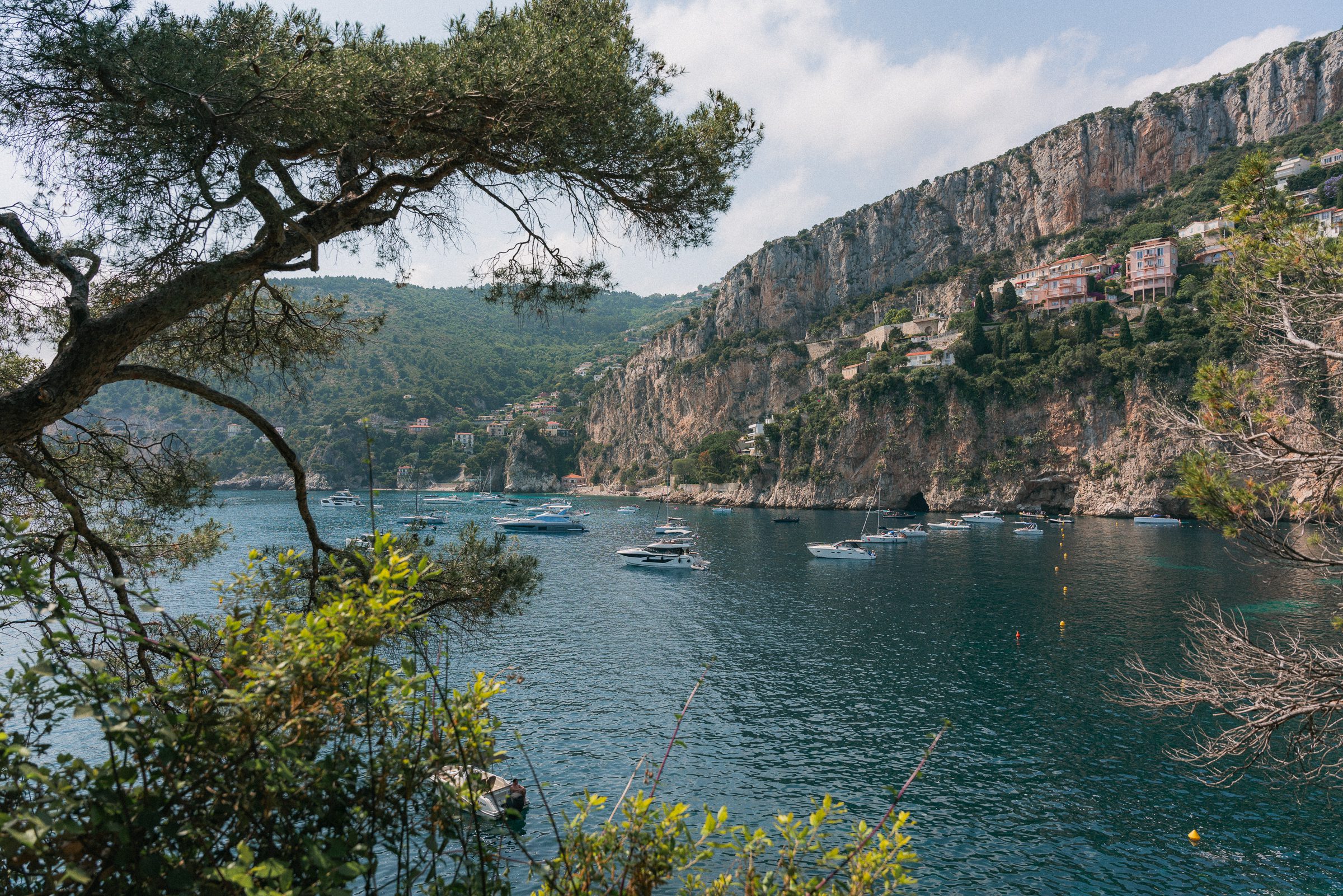 boats moored below cliffs at Mala Beach in Cap-d'Ail, French Riviera