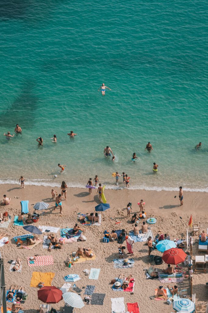 people swimming and lounging on the beach in Villefranche-sur-Mer, French Riviera